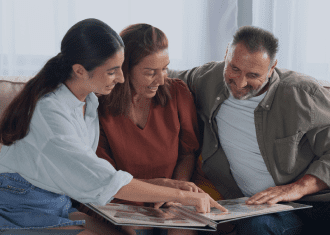 Three people looking at a magazine together.