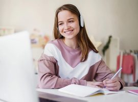 A girl with headphones on sitting at her desk