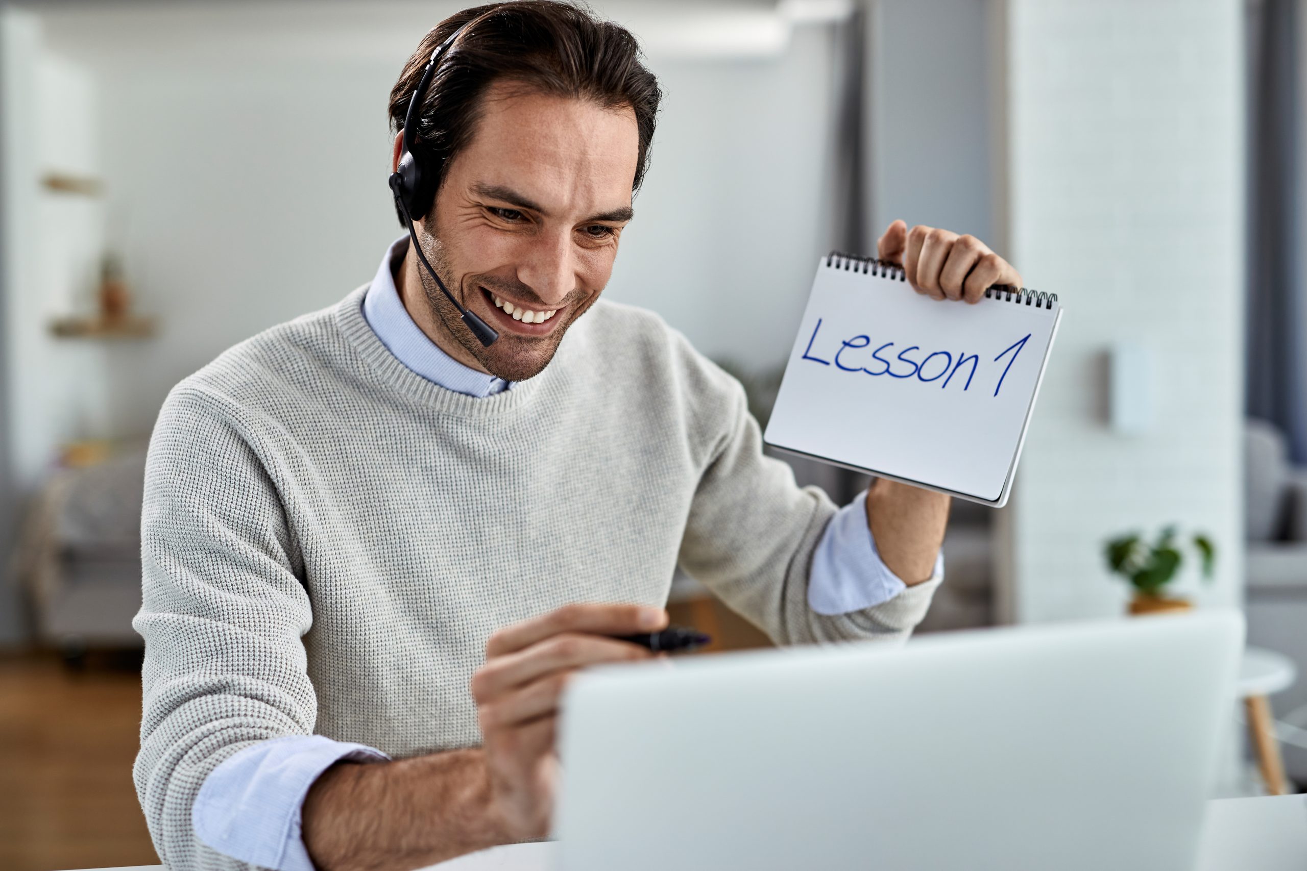 A man holding up a piece of paper with the word lesson 1 written on it.