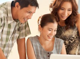 Three people looking at a laptop screen